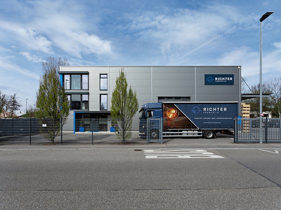 Komplette Ansicht des Unternehmensgebäudes von Richter Formteile von der gegenüberliegenden Straßenseite mit LKW im Hof.