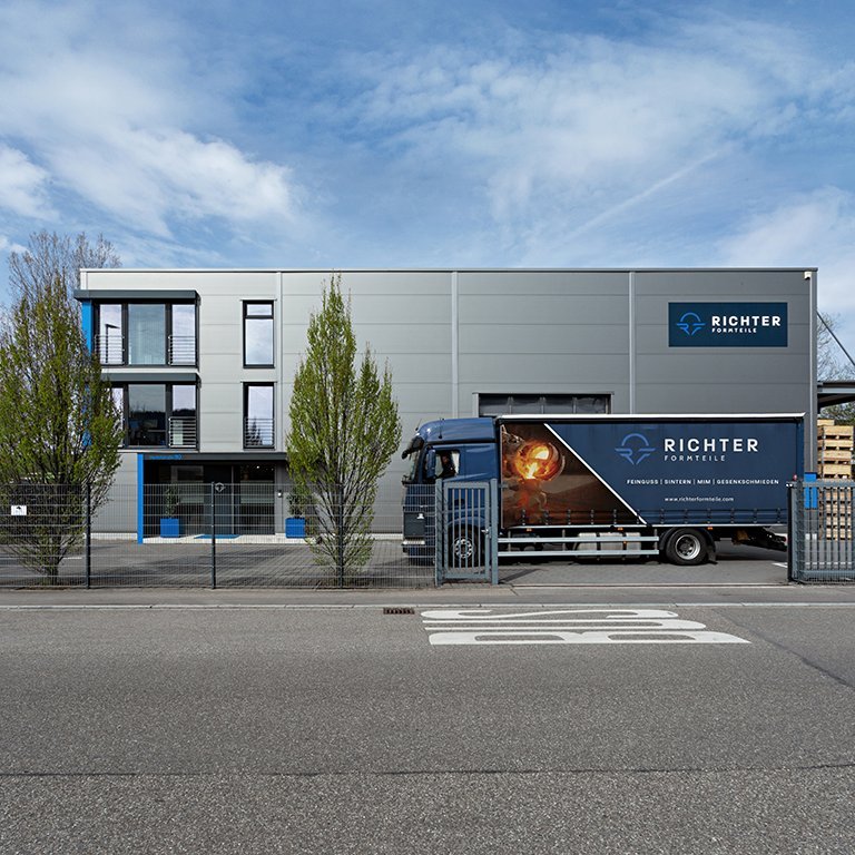 Komplette Ansicht des Unternehmensgebäudes von Richter Formteile von der gegenüberliegenden Straßenseite mit LKW im Hof.